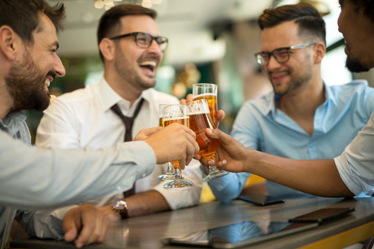 Businessmen sit in pub and drinking beer after work