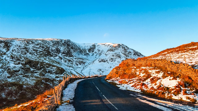 Snow winter sunset at the top of Kirkstone Pass, Cumbria, UK. Lake District's highest pass that is open to motor traffic and it connects Ambleside to Patterdale in the Ullswater Valley. The A592 road.