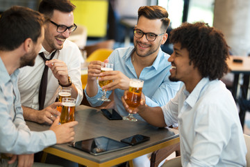 Funny conversation four businessmen while sit pub and drinking beer after work