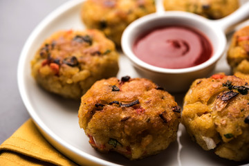 Veg Poha Cutlet or flattened Rice Patties served with tomato ketchup and green chutney