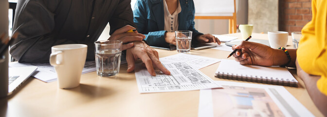 Architect and interior designers are brainstorming for the projects in a meeting at the office. Multi Ethnic diversity business people. African, American, Asian working together. 