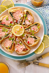 Salmon in puff pastry, Salmon, spinach and dried tomatoes wrapped in puff pastry in portions, drizzled with with lemon juice on a plate, top view. Stuffed french pastry, delicious appetizer 