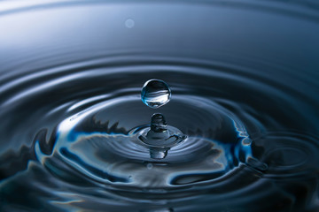 Naklejka na ściany i meble Splash of water close-up. Water drop. A blue drop of water. Falling water. The rain closeup.