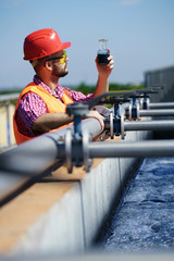 An engineer controlling a quality of water ,aerated activated sludge tank at a waste water treatment plant.  pollution  