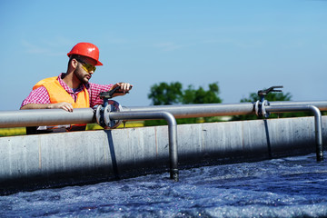 An engineer controlling a quality of water ,aerated activated sludge tank at a waste water...