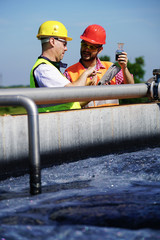   Engineers controlling a quality of water ,aerated activated sludge tank at a waste water treatment plant 