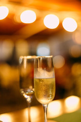 two glasses champagne bokeh garlands yellow festive