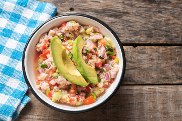 Mexican fish  ceviche with avocado on wooden background