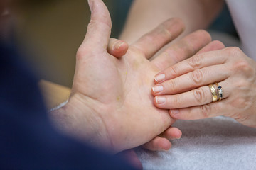 Massager massaging man's hand at spa