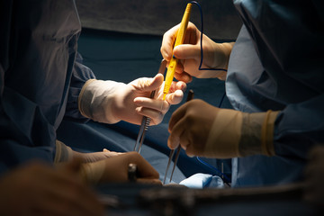 Surgeons using cauterizing tool operating on patient at hospital