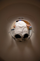 Low section of patient lying in CAT Scan Machine at hospital