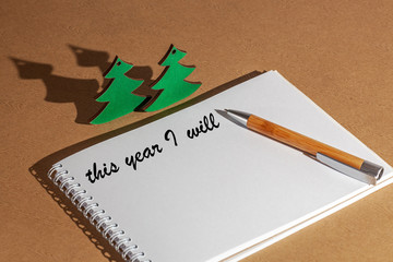 white sheet of notebook for notes, pen on top, wooden background, concept of goals and plans and tasks for the new year, wish list,