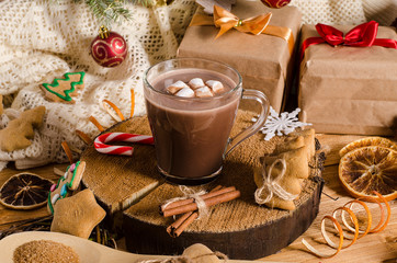Hot Christmas and New Year's drink of cocoa with marshmallows on a table with gifts, Christmas...