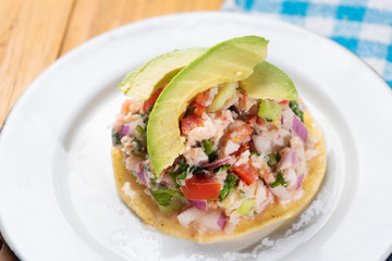 Mexican fish  ceviche with avocado on wooden background