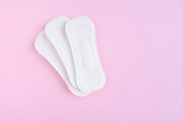Daily soft cotton pads with selective focus on pink background with empty space for text. Menstrual pad. Women's health concept monthly period days. Woman critical days, menstruation cycle 