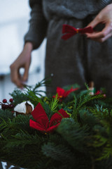 Decorative Christmas wreath with poinsettia, mistletoe leaves, fir branches and holly berries.