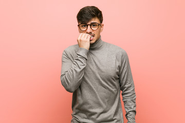 Young smart student man biting fingernails, nervous and very anxious.