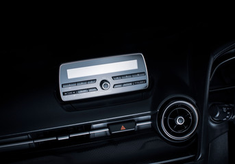 Audio multimedia player and radio on car console panel and emergency light button in a luxury car.