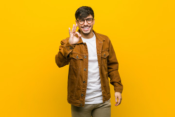 Fototapeta premium Young hispanic casual man cheerful and confident showing ok gesture.