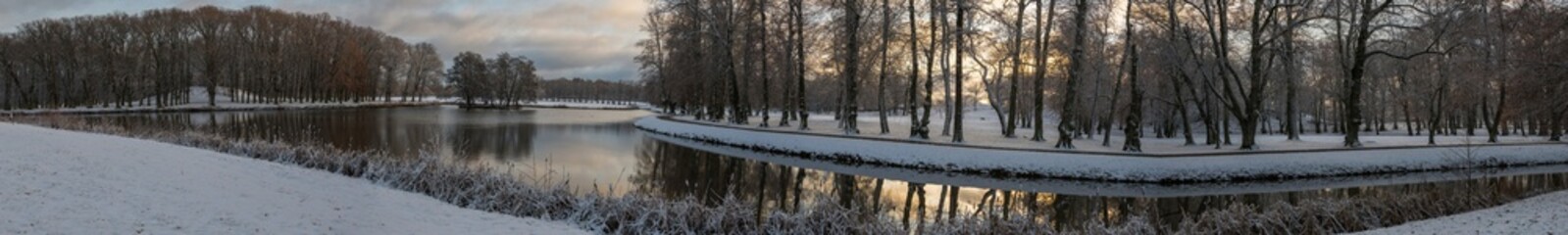 Snowy sunset park view at a pond on the Drottningholm island 