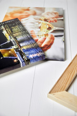 Canvas prints on white wooden table.  Photo industry. Colorful photographs stretched on stretcher bars. Photos printed on glossy synthetic canvas with gallery wrapping