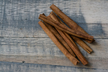 Raw cinnamon sticks on a wooden background