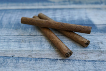 Three cigars placed on a wooden board
