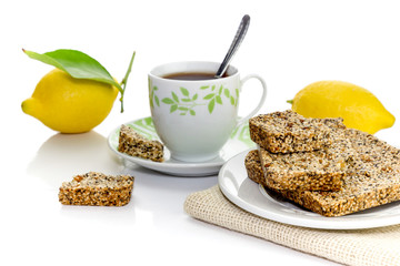 National, traditional, Greek sweets (pasteli) from honey, sesame, poppy seed and lemon rind and cup with tea
