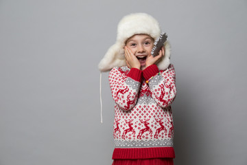 Smiling girl in the winter look on the grey