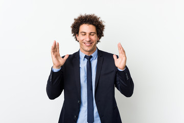 Young business curly man against white background joyful laughing a lot. Happiness concept.