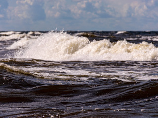 blurred foreground with sparkling waves, clouds and sea in the background