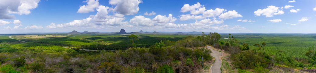 Fototapeta na wymiar Panorama Australian landscape taking in Glass House Mountains, area of bush and farms with pine forests