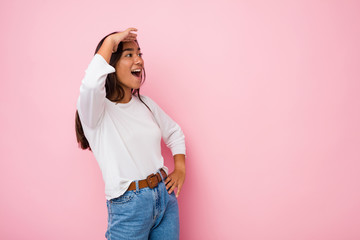 Young mixed race indian woman looking far away keeping hand on forehead.