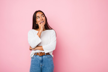 Young mixed race indian woman relaxed thinking about something looking at a copy space.