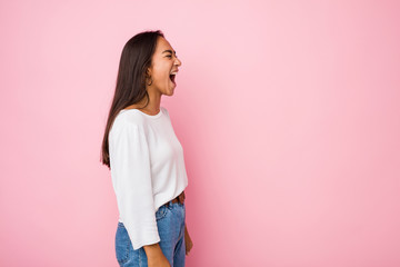 Young mixed race indian woman shouting towards a copy space