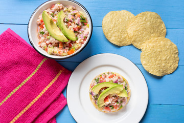 Mexican fish  ceviche with avocado on blue background