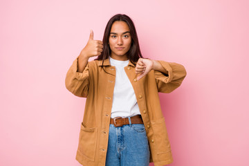 Young mixed race indian woman isolated showing thumbs up and thumbs down, difficult choose concept