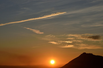 Nice sunset with the solar disk hiding along the horizon and the mountains of Sierra Elvira ahead