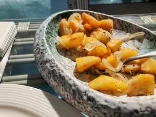 Fried potatoes with onions on a platter