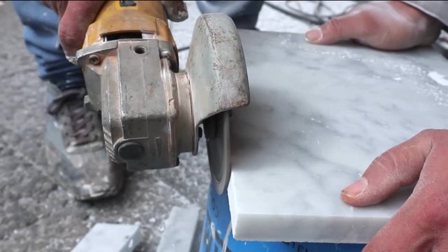 Real time footage for grinding machine. Technician saw machine cut  marble stone. Worker cutting marble using grinding machine in close up 