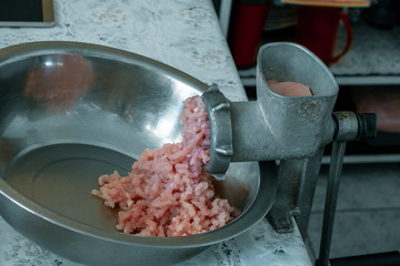 Vintage meat grinder and minced meat. The process of grinding meat in an old meat grinder