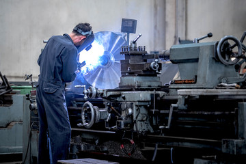 Workers is milling metal parts with lathes machines with high precision in the work process, Manufacturing industrial.