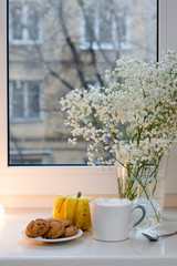 Gypsophila bouquet on the window in a glass vase at dusk.