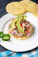 Mexican fish  ceviche with avocado on dark background