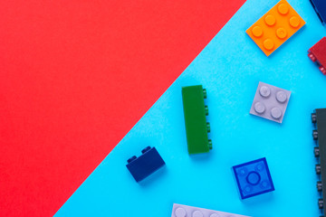 Multicolor plastic blocks of a children's designer on a colored background.