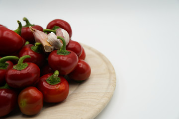 Close-up of red hot chili peppers on plate. Fresh spices ingredients on white background. Raw healthy vegetables