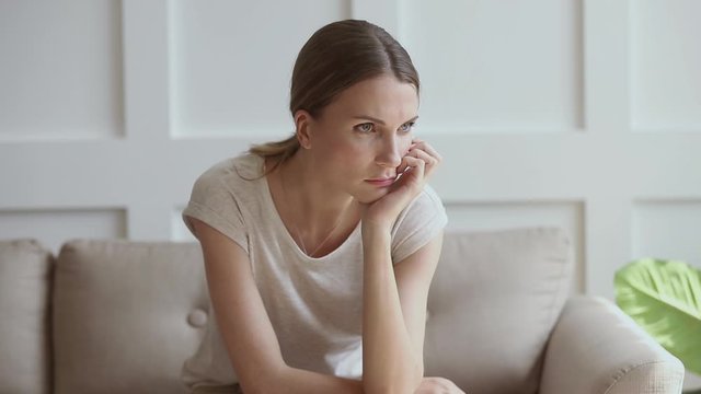 Worried insecure lady thinking of problem sitting alone at home