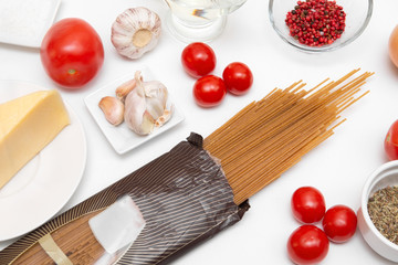 spaghetti, pasta, cheese, pepper, garlic, tomatoes on a white