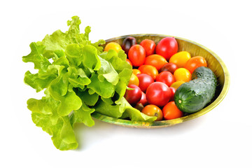 lettuce yellow and red tomatoes, cherry tomatoes and cucumber on a vintage dish white background, isolate, front view