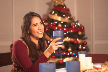 joven mexicana brindando enfrente de árbol de navidad